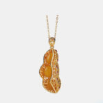 Pendentif en forme de haricots avec des pierres d'ambre sur fond blanc.