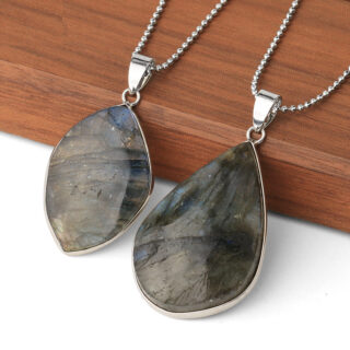 Deux colliers avec une pierre de labradorite avec une chaine en argent sur une plaque en bois