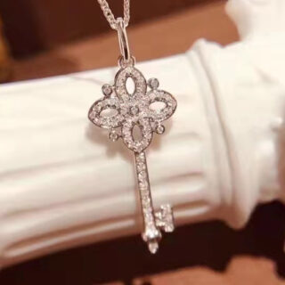 On voit un collier clé argenté serti de brillants.