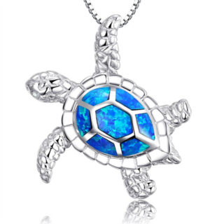 Sur fond blanc, on voit un pendentif tortue argenté et bleu.