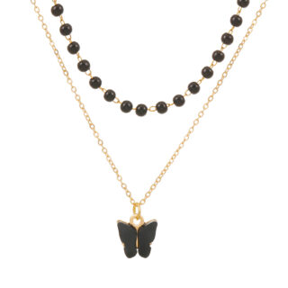 pendentif en forme de papillon noir, relié à une chine dorée, avec un collier avec chaine dorée et perles noires, sur fond blanc
