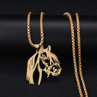 Pendentif cheval doré avec chaine sur fond noir.