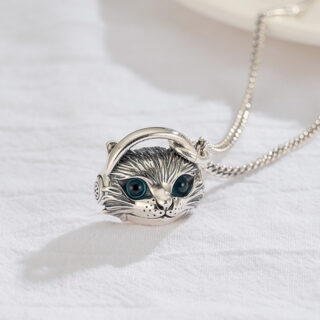 Petit pendentif avec une tête de chat sur fond blanc.