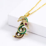 Pendentif coloré représentant deux serpents, fond blanc.