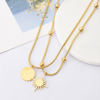 On voit un collier doré double rang qui représente un soleil.