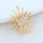 Sur fond blanc, on voit un pendetif doré motif soleil.