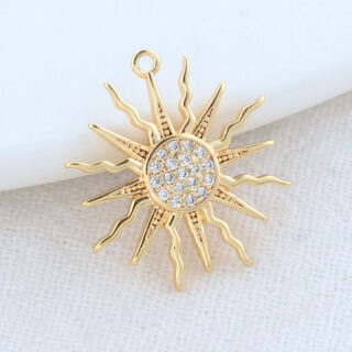 Sur fond blanc, on voit un pendetif doré motif soleil.