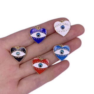Photo d'une main tenant plusieurs petits pendentifs oeil en forme de coeur de différentes couleurs