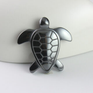 On voit un pendentif en forme de tortue. Il est gris foncé.