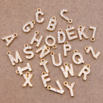 Pendentifs en forme de lettres de l'alphabet avec des petits diamants incrustés disposées en désordre sur le sol