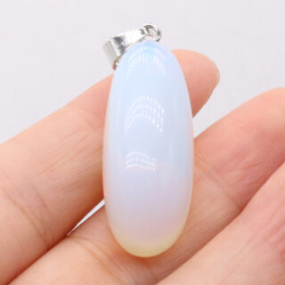 Personne tenant une pierre d'opale allongée blanche dans ses mains.