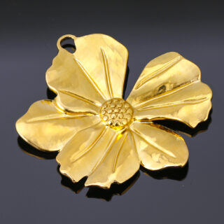 pendentif doré en forme de fleur sur fond noir lumineux