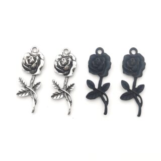 4 pendentifs en forme de rose, deux argentés sur la gauche et deux noirs sur la droite, en métal, sur fond blanc