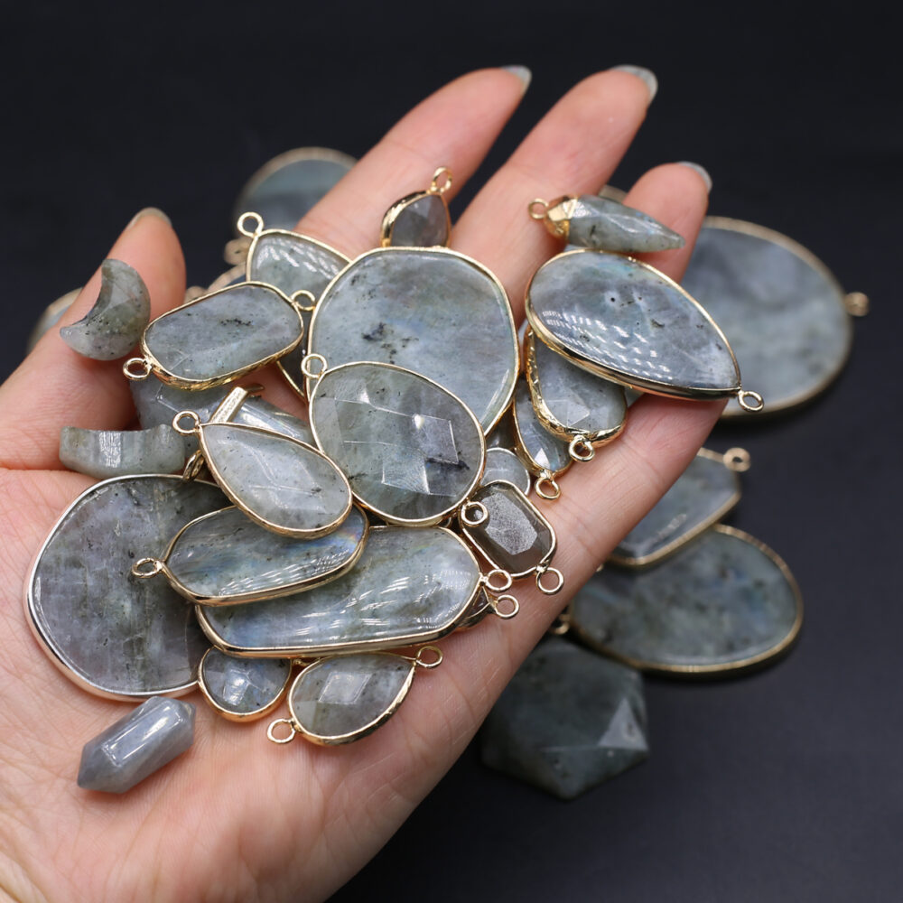 Main tenant des pendentifs en pierre de labradorite