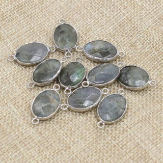 Pendentifs en pierre de labradorite disposées sur un tissu beige