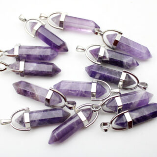 Pendentifs en améthystes posé sur une surface blanche