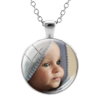 Photo d'un pendentif personnalisé avec une photo d'un bébé, au bout d'une chaine de collier