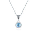 Pendentif argenté avec une topaze bleue en son centre. Fond blanc.