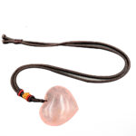 Pendentif quartz rose en forme de cœur avec une chaine sur fond blanc.