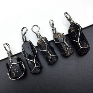 Photo de pierre de tourmaline noires brutes en pendnetif avec du fil de fer.