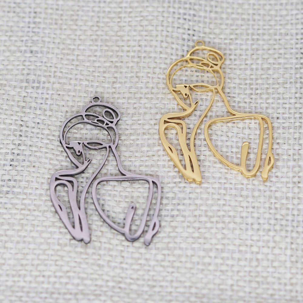 On voit deux pendentifs qui représentent deux silhouettes de femme. Le premier est argenté, l'autre doré.