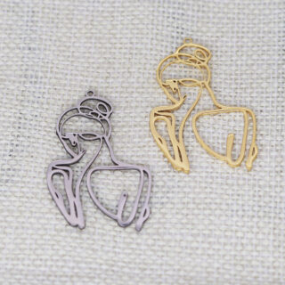 On voit deux pendentifs qui représentent deux silhouettes de femme. Le premier est argenté, l'autre doré.