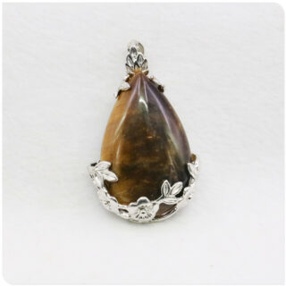 Photo d'un pendentif en pierre oeil de tigre sur un socle en argent plaqué à fleurs