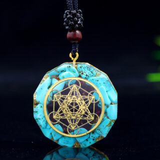 Photo d'un pendentif en orgonite bleu avec un dessin de géométrie sacré doré