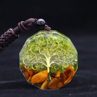 Photo d'unc ollier pendentif orgonite en olivine verte motif arbre de vie sur fond noir