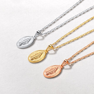 Trois pendentifs sur des chaines, alignées, de couleur argentée, dorée et rose dorée.