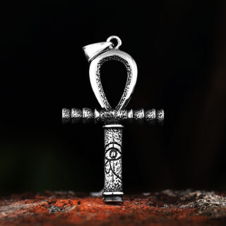 Pendentif en forme d'amulette égyptienne posée sur du bois.