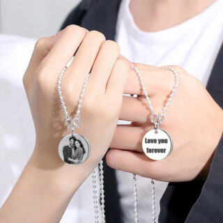 Photo de deux mains tenenat des colliers à pendentif personnalisés rond en argent avec une photo et du texte
