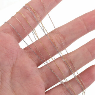 Photo d'une main tenant plusieurs chaines à maille cheval de différentes couleurs