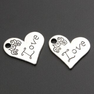 Photo de deux pendentif en forme de coeur gravé love