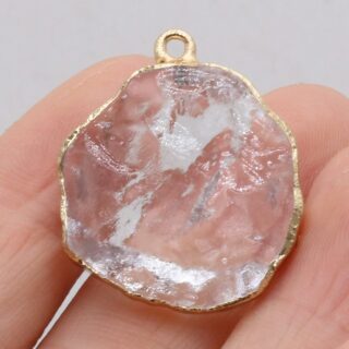 Photo d'un pendentif en cristal de roche transparent dans une main