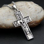 Pendentif croix en acier inoxydable sur une pierre