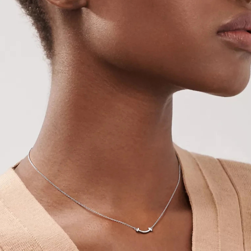 Pendentif femme minimaliste et moderne porté par une femme sur fond gris