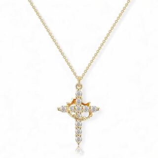 Pendentif en forme de croix stylisée sertie de strass, traversant par une couronne métallique dorée, suspendue à une chaîne fine, sur fond blanc.