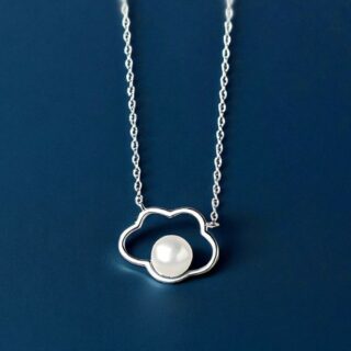 Petit pendentif en forme de nuage creux avec perle ronde au centre, sur chaîne fine en argent, sur fond neutre bleu foncé