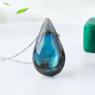 Pendentif en forme de goutte en pierre de lune bleue sur chaîne fine argentée.